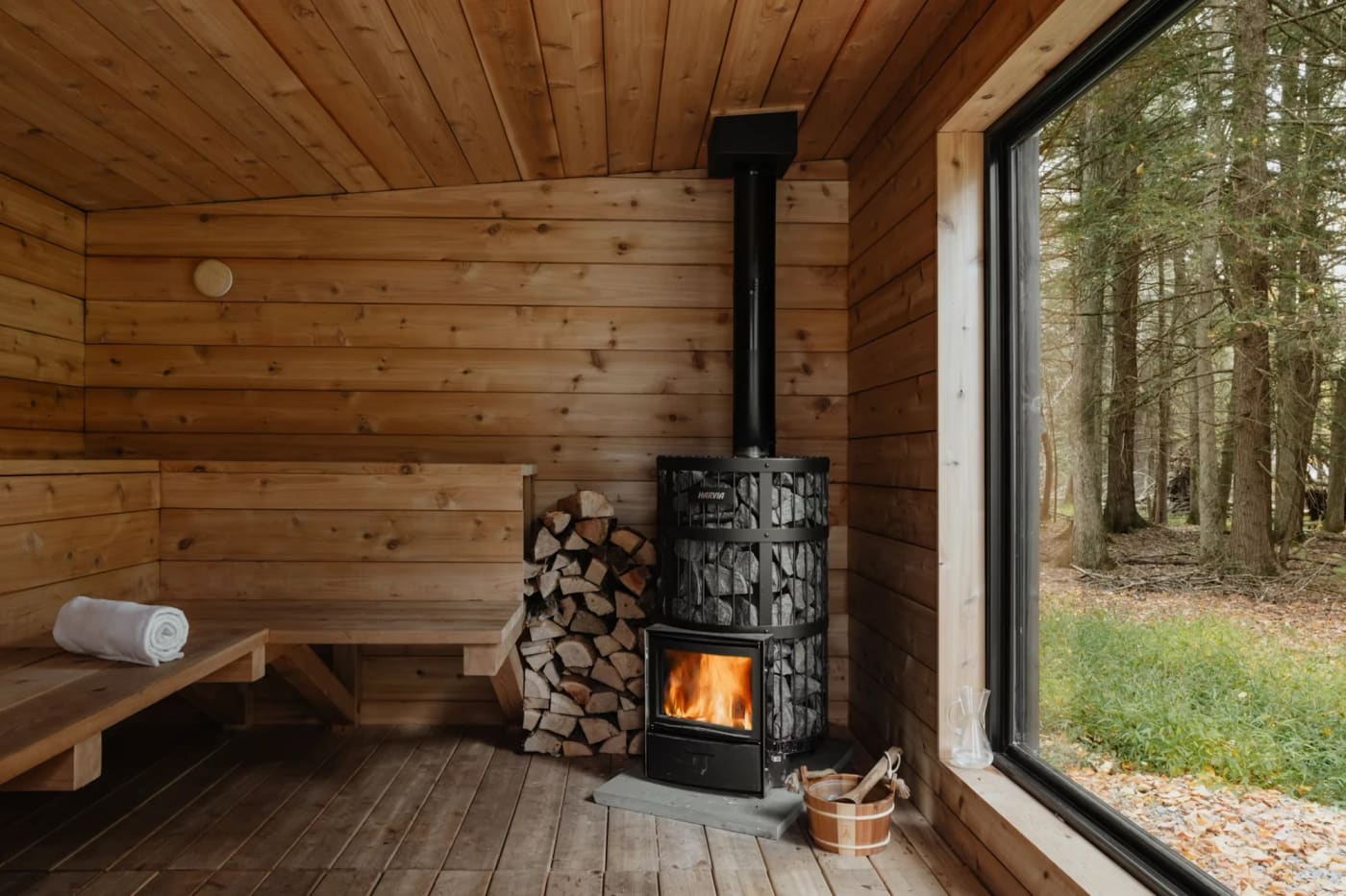 Sauna with a wood stove and a window towards the forest