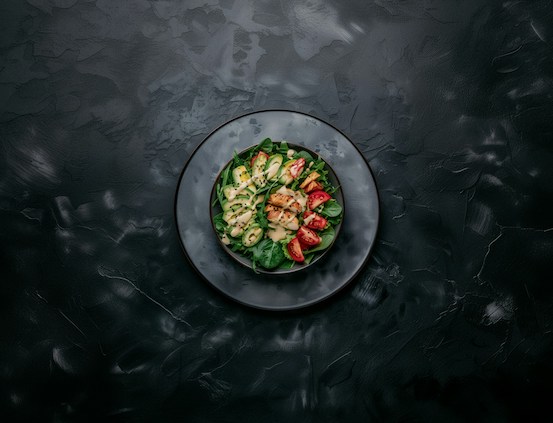 Salad with chicken and vegetables on a dark plate